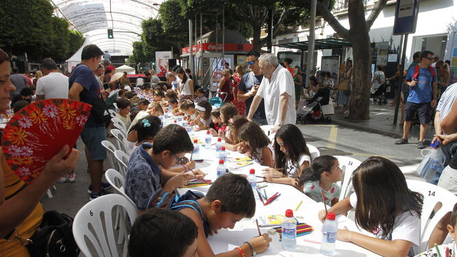 Varios niños dibujan sus sueños más bonitos de la Feria almeriense en el Paseo de Almería.