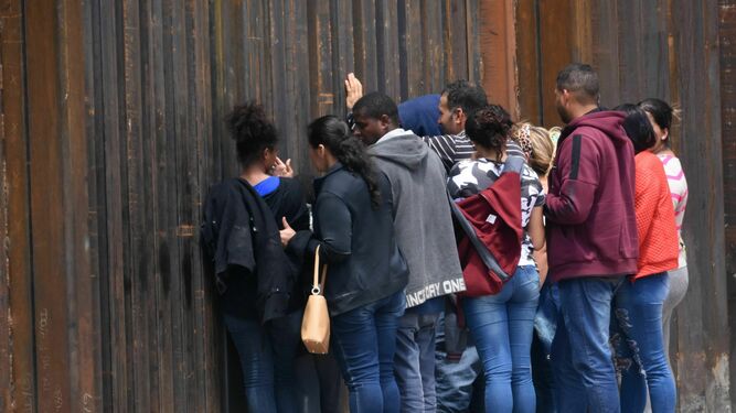 Migrantes centroamericanos se asoman por el muro fronterizo para entregarse a las autoridades migratoria estadounidenses en el tramo de Puente Nuevo, en Ciudad Juárez, el pasado agosto.