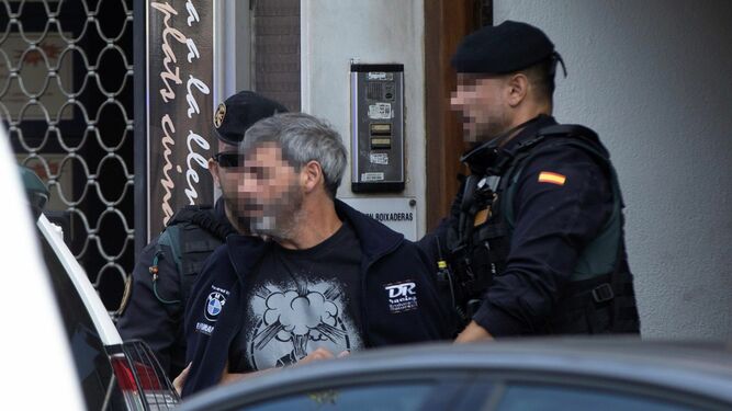 Agentes de la Guardia Civil acompañan a uno de los nueve detenidos  durante el registro de un domicilio en Sabadell.