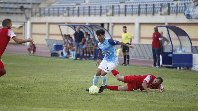 Un jugador celeste supera a un rival en una jugada sobre el césped de Santo Domingo.