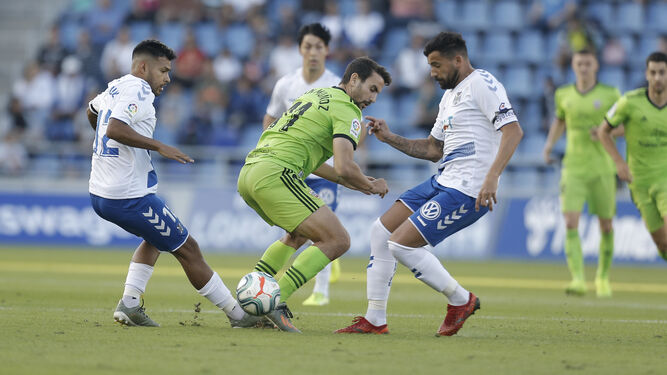 Juan Muñoz intenta zafarse del acoso de dos rivales en el Heliodoro Rodríguez López de Tenerife.