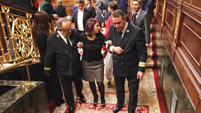 La portavoz del PSOE en el Congreso, Adriana Lastra, es ayudada para salir del hemicliclo tras su caida durante la sesión de constitución de la XIV legislatura este martes en el Congreso.