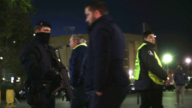 Un mosso d'Esquadra, junto a un guardia de seguridad, en el entorno del Campo Nou durante otro partido.