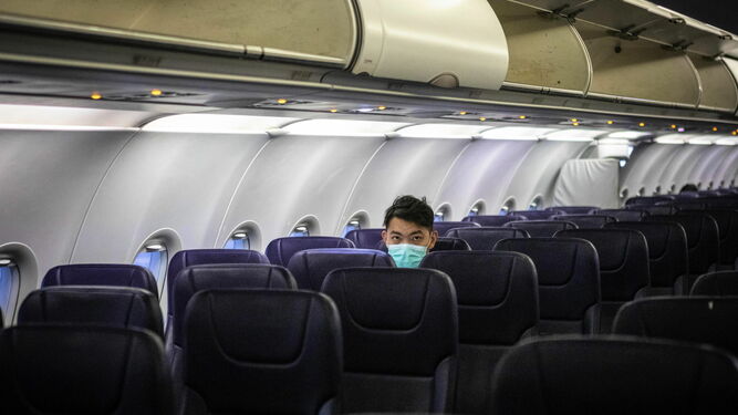 Un pasajero chino con una mascarilla para evitar contagios.