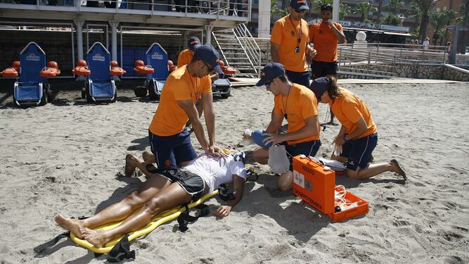Socorristas reaniman a un bañista en un simulacro realizado en la playa de El Zapillo.