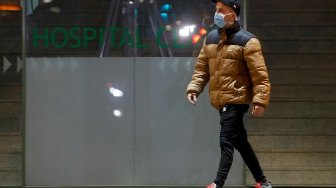 Un hombre camina con una mascarilla en los aledaños del Hospital Clínic de Barcelona