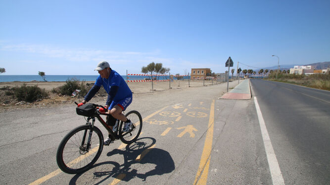Un ciclista transita fuera ya del paseo marítimo, en la zona pendiente de ampliar