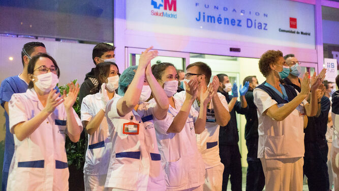 Trabajadores sanitarios aplauden a la salida del Hospital Universitario Fundación Jiménez Díaz en Madrid.