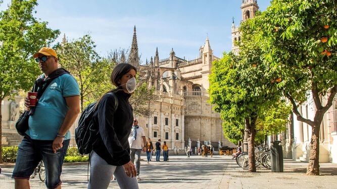 Varios turistas pasean por las calles céntricas de Sevilla.
