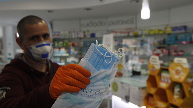 Un usuario de una farmacia almeriense, con varias mascarillas recién compradas.