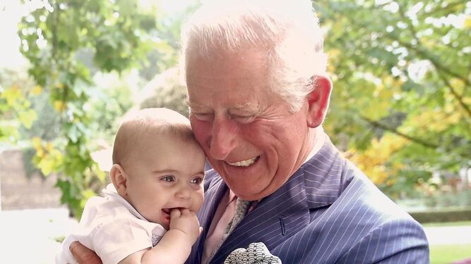 Carlos de Inglaterra, sonríe con su nieto Luis en brazos cuando era un bebé.