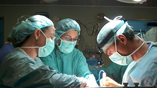 Un equipo de cirujanos en la mesa de  operaciones.