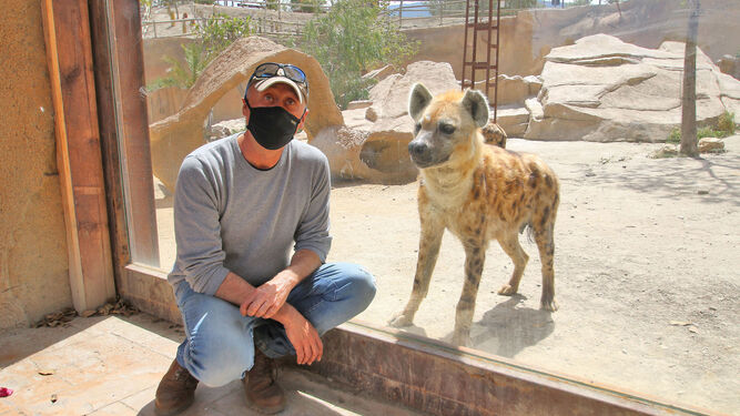 José María Rodríguez junto a una hiena manchada. Un cristal los separa.