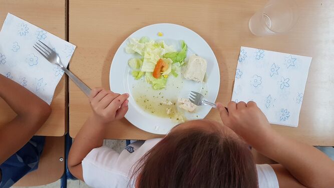 Una niña almorzando en un comedor.
