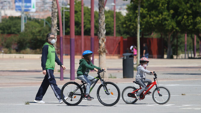 Menores pasean por Almería con la bicicleta protegidos con mascarillas infantiles.