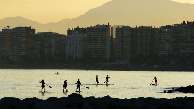 Varias personas disfrutan de deportes acuáticos en la Malagueta.