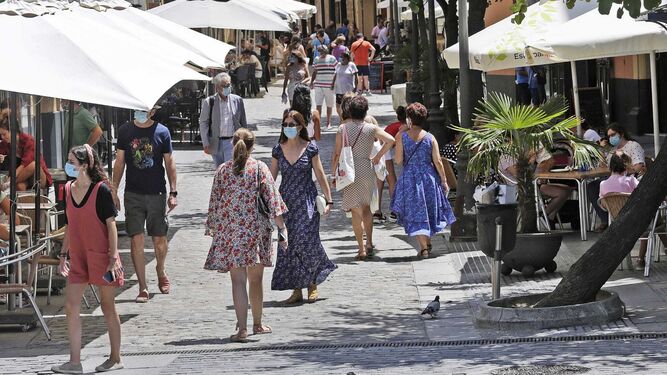 Varias personas con mascarilla pasean por una céntrica calle de Cádiz.