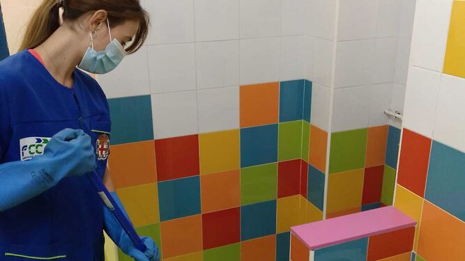 Una trabajadora limpia los baños de un colegio