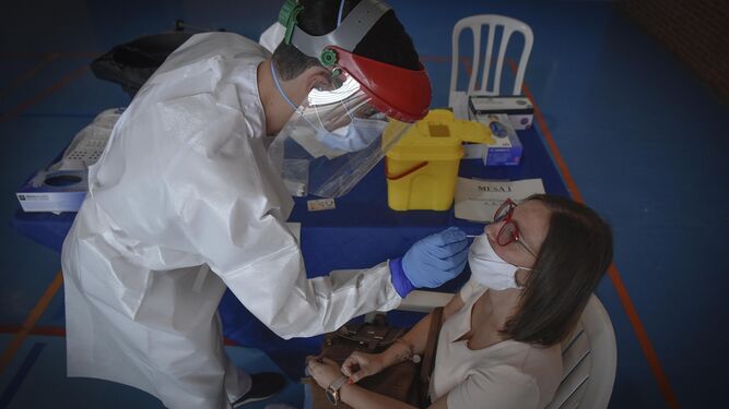 Un sanitario toma una muestra a una mujer, en Écija (Sevilla)