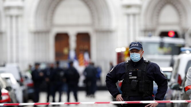 Agente de policía vigila la zona acordonada junto a la basílica de Notre Dame de Niza, donde un hombre asesinó a cuchilladas a tres personas.