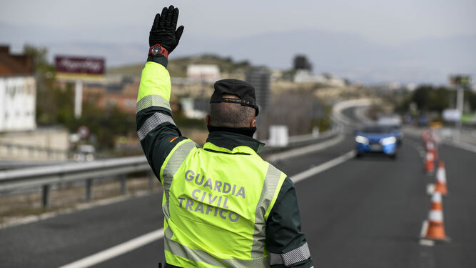 Un agente de la Guardia Civil ordena el alto a un vehículo en Granada.