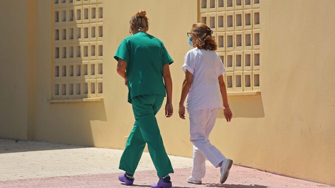 Una enfermera y  una doctora caminan juntas.