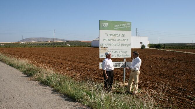 Imagen de archivo de dos productores junto a un cartel del extinto IARA en Málaga