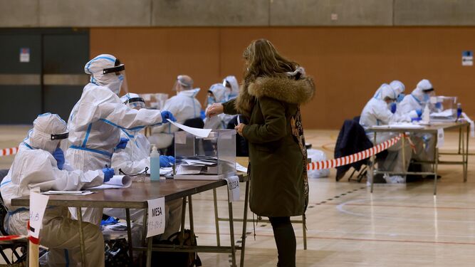 Integrantes de las mesas de votación equipadas con equipos de protección individual (EPI), en el Polideportivo Municipal de la España Industrial de Barcelona.