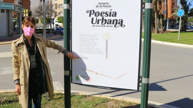 La concejala Julia Ibáñez junto al cartel de la Semana de la Poesía de El Ejido.
