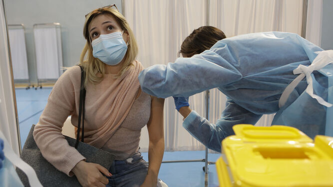 Una enfermera administra una vacuna de Astrazeneca a una mujer.