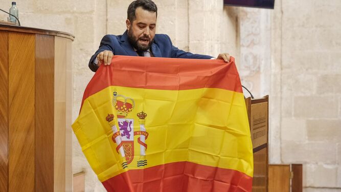 Fran Carrillo, diputado de Ciudadanos, sostiene una bandera de España durante el debate en el Parlamento.