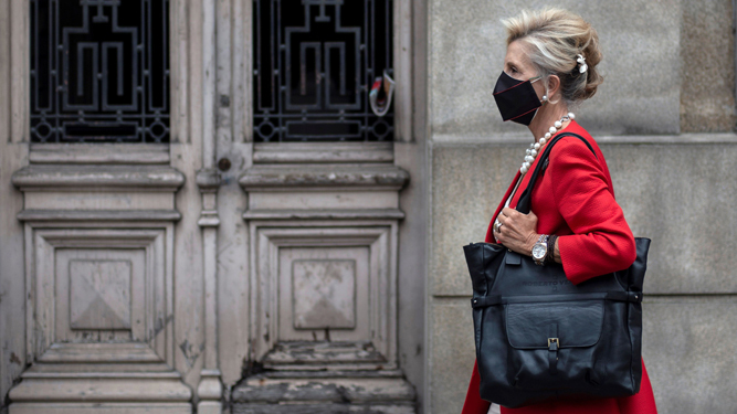 Una mujer camina con mascarilla por una céntrica calle de Orense.