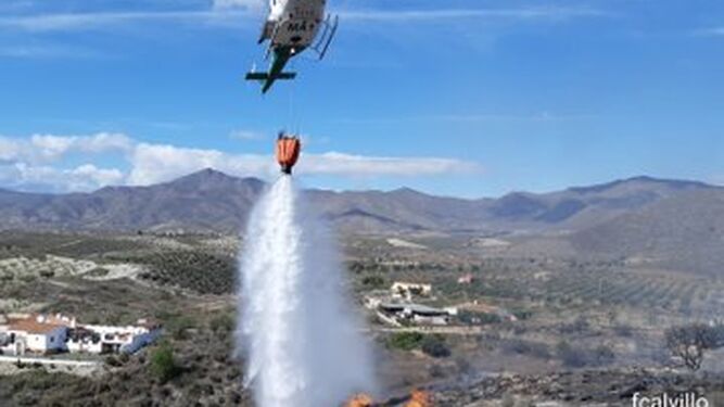Un helicóptero arroja agua en uno de los puntos calientes del incendio.