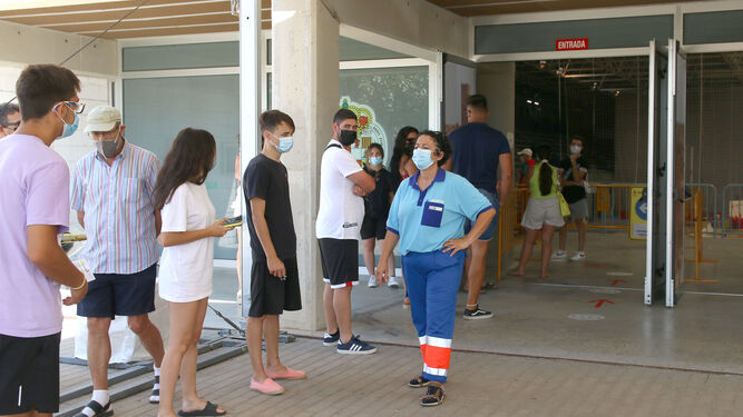 Jóvenes haciendo cola en el Palacio de los Juegos Mediterráneos para recibir la primera dosis.