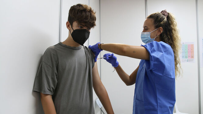 Un joven se vacuna conta la COVID-19 en el Palacio de los Juegos Mediterráneos.