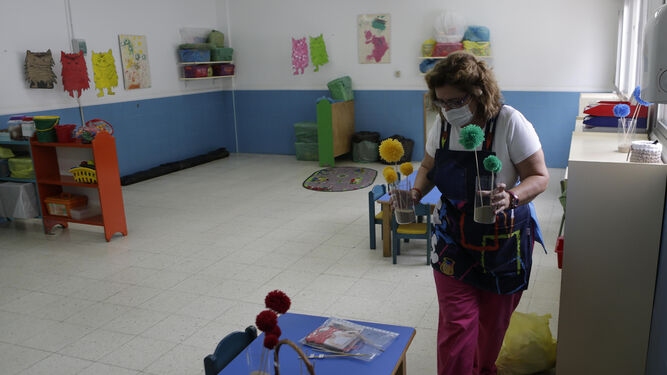 Una monitora de Infantil prepara el aula de una guardería.