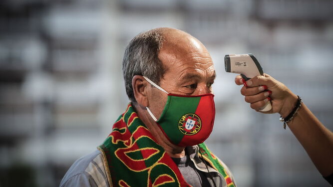 Un aficionado portugués pasa un control de temperatura en el acceso  al estadio Alvalade de Lisboa.