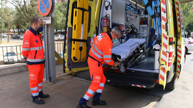 Dos operarios del 061, junto a una ambulancia.