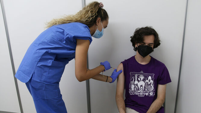 Joven almeriense se vacuna contra la covid-19 en el Palacio de los Juegos Mediterráneos.