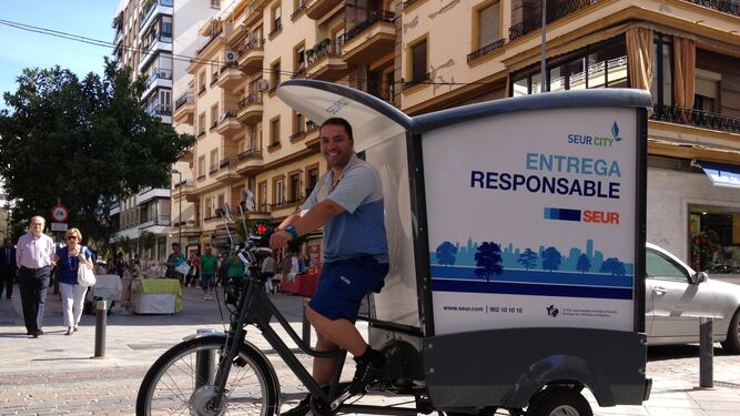 Un operario de Seur  pasa por Asunción en la bicicleta de reparto