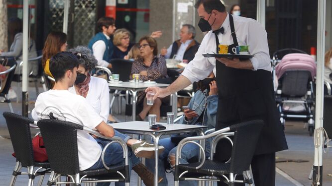 Un camarero atiende a unos clientes.