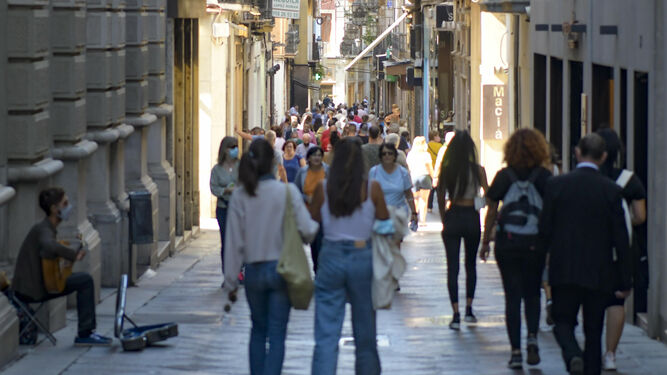 Mujeres y hombres en una calle de Granada.