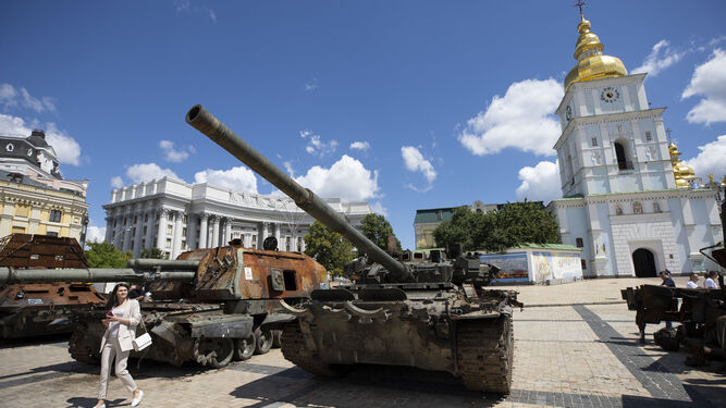 Personas recorren la exhibición de tanques rusos destruidos, que están instalados en la plaza San Miguel, en Kiev.