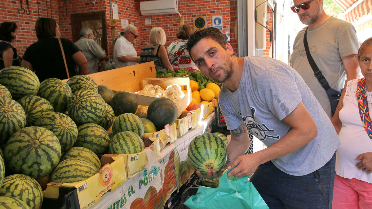 Paco selecciona un ejemplar de sandía delante de su frutería, sita junto al Mercado de Los Ángeles.