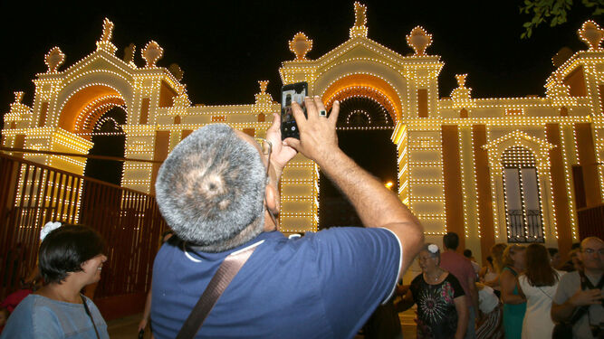 Un hombre fotografía la portada principal de la Feria de Almería