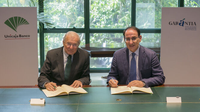 El presidente de Unicaja Banco, Manuel Azuaga, y el de Garántia, Javier González de Lara, firman la renovación del acuerdo.