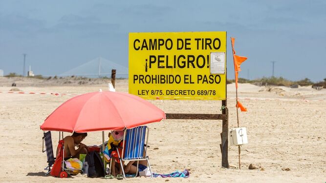 Cartel que limita la zona restringida por el campo de tiro en la playa de Camposoto.