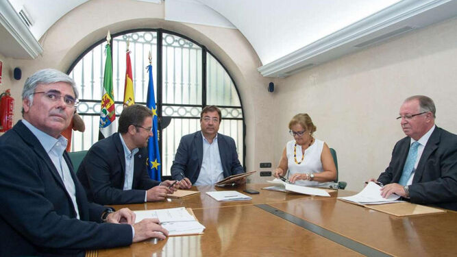 Un momento de la firma del protocolo entre Guillermo Fernández Vara y Enrique Pelegrín, primero por la derecha.