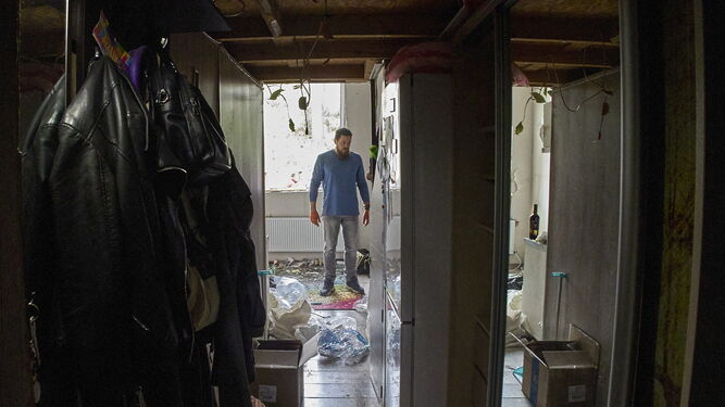 Un hombre inspecciona los daños provocados por los bombardeos en su vivienda de Jarkov.