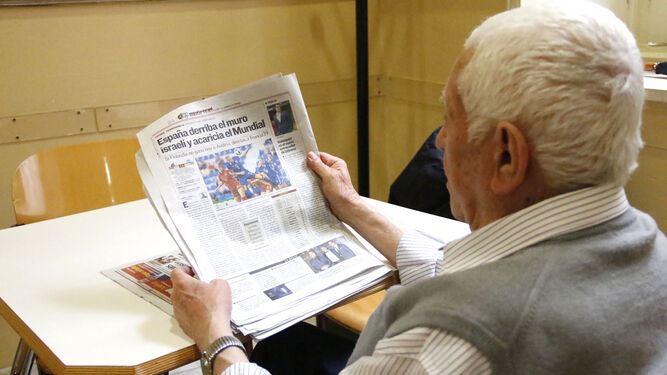 Una persona de la tercera edad lee el periódico.